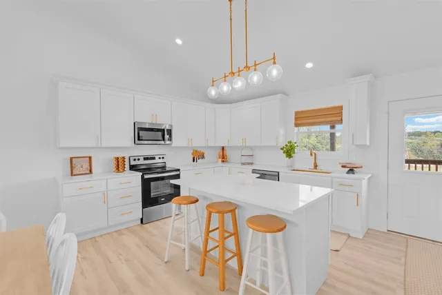 a large kitchen with stainless steel appliances kitchen island granite countertop a sink and cabinets