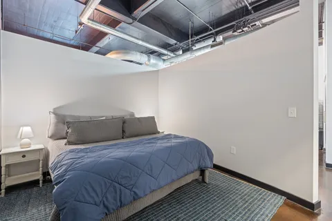 a bedroom with a bed and wooden floor