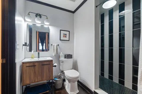 a bathroom with a toilet a sink and mirror
