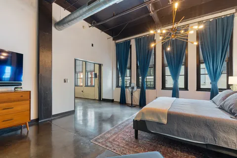 a spacious bedroom with a large bed and a large window