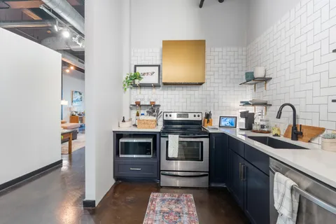 a kitchen with stainless steel appliances a stove a sink and a microwave