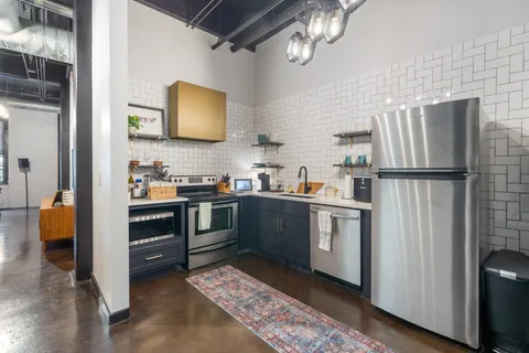 a kitchen with a refrigerator and a stove top oven