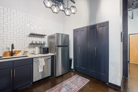 a kitchen with stainless steel appliances granite countertop a refrigerator and a sink