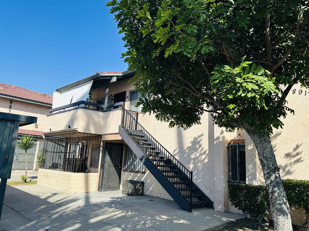 891 West San Ysidro Boulevard, Unit 9 San Ysidro, CA 92173 - Photo 15 of 18 a view of a house with a tree and wooden fence