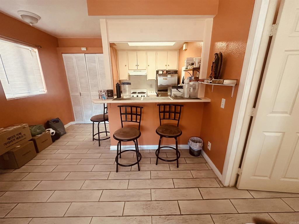 891 West San Ysidro Boulevard, Unit 9 San Ysidro, CA 92173 - Photo 2 of 18 a dining room with furniture and a floor to ceiling window
