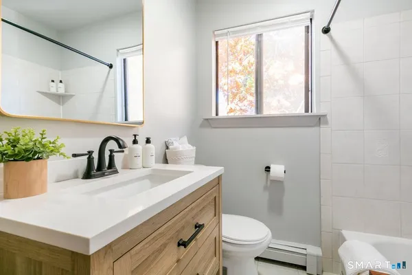 a bathroom with a sink a toilet and a mirror