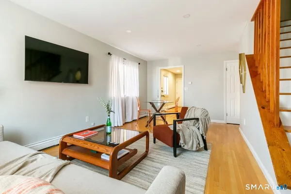 a living room with furniture flat screen tv and a large window