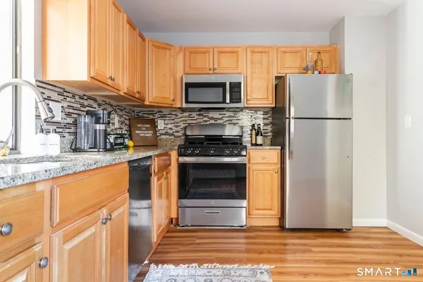 a kitchen with granite countertop a refrigerator stove and oven