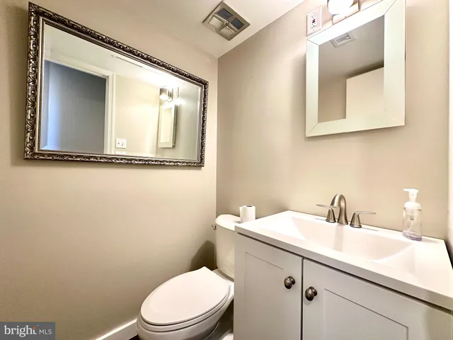 a bathroom with a toilet a sink and mirror