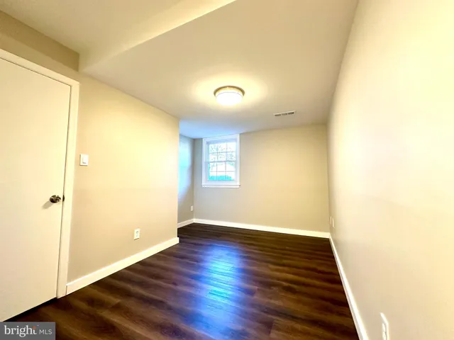 a view of an empty room with wooden floor