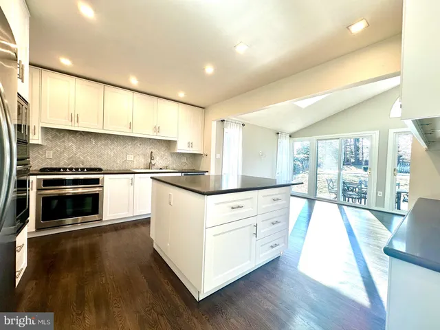 a kitchen with granite countertop white cabinets and white appliances