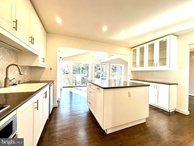 a large kitchen with stainless steel appliances a lot of counter space and wooden floor