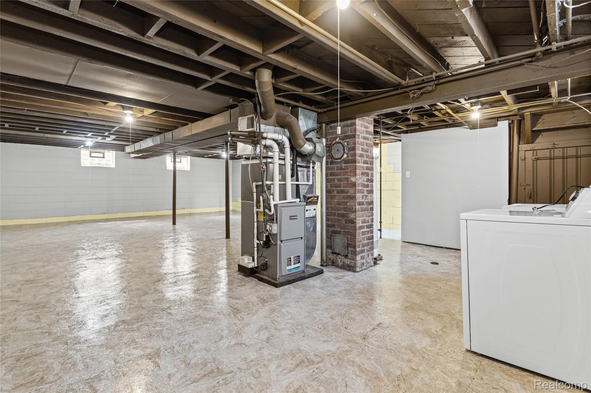 26508 Five Mile Road Redford, MI 48239 - Photo 32 of 41 Spacious basement area featuring exposed ceiling joists, concrete flooring, and a brick support column