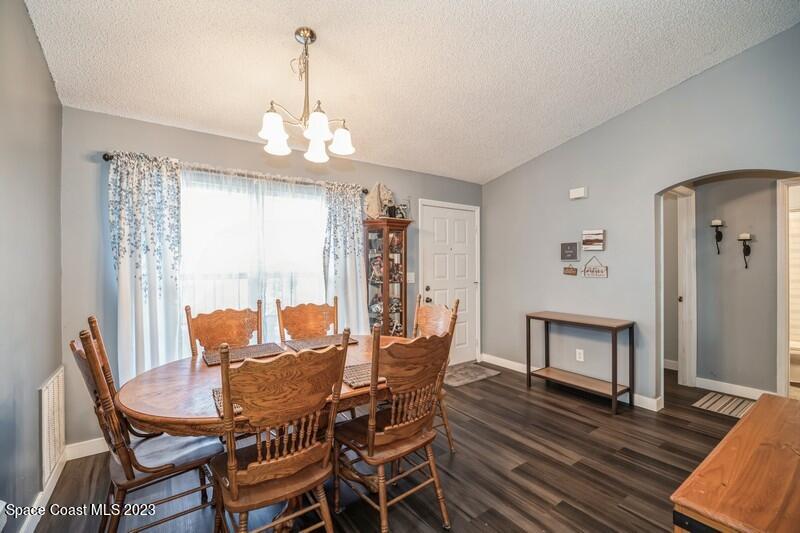 6475 Addax Avenue Cocoa, FL 32927 - Photo 10 of 31 a dining room with furniture a chandelier and wooden floor