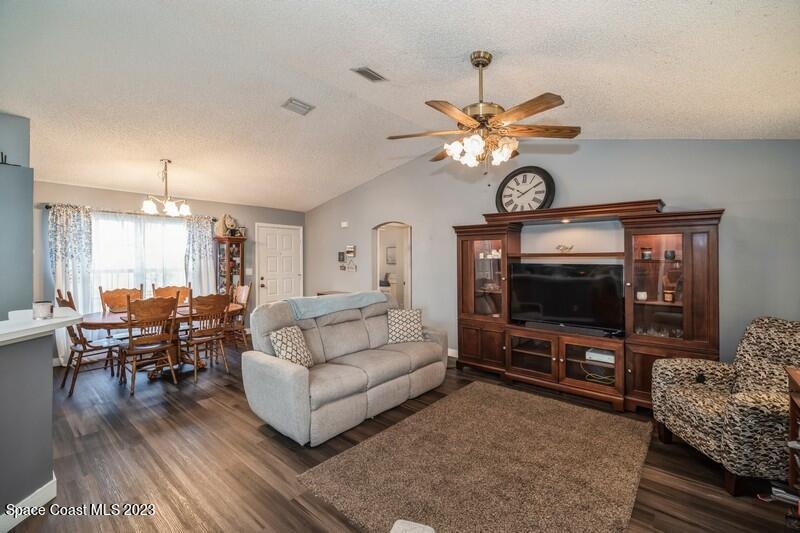 6475 Addax Avenue Cocoa, FL 32927 - Photo 13 of 31 a living room with furniture a flat screen tv and a chandelier
