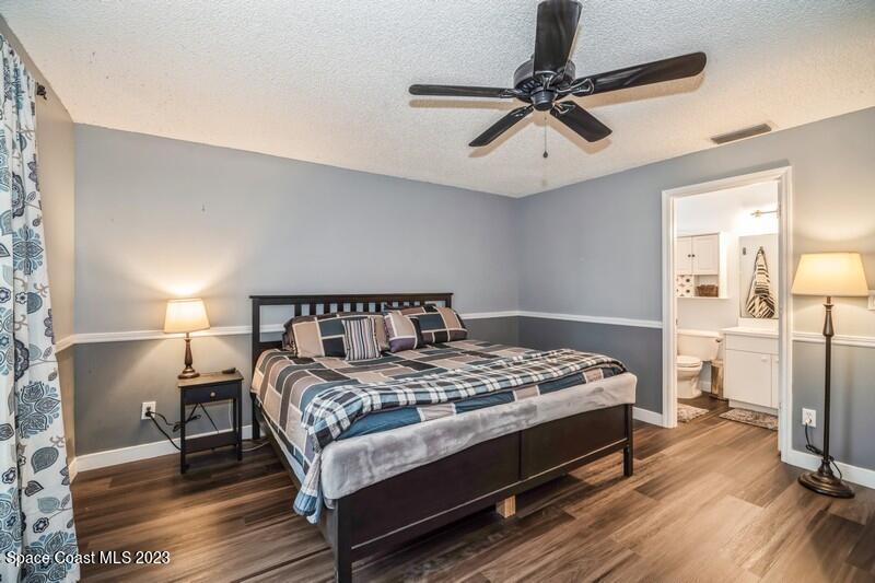 6475 Addax Avenue Cocoa, FL 32927 - Photo 17 of 31 a bedroom with a bed and a chandelier