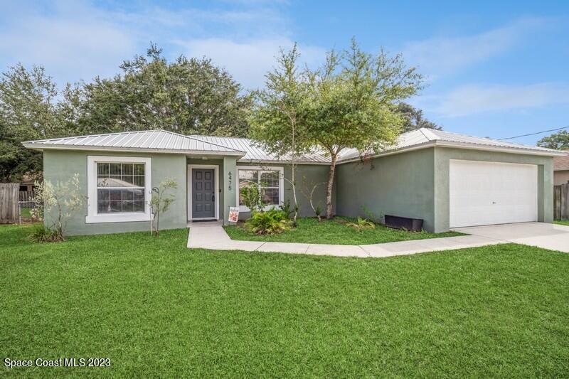 6475 Addax Avenue Cocoa, FL 32927 - Photo 2 of 31 a front view of a house with a yard and garage