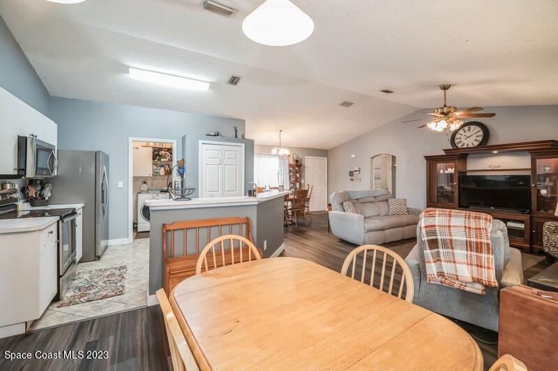 6475 Addax Avenue Cocoa, FL 32927 - Photo 26 of 31 a living room with furniture a flat screen tv and kitchen view