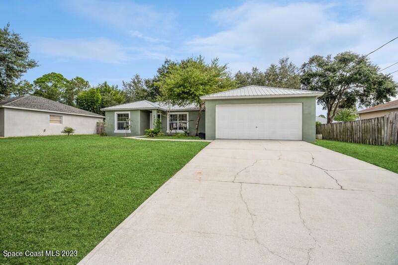 6475 Addax Avenue Cocoa, FL 32927 - Photo 3 of 31 a front view of a house with a yard and garage