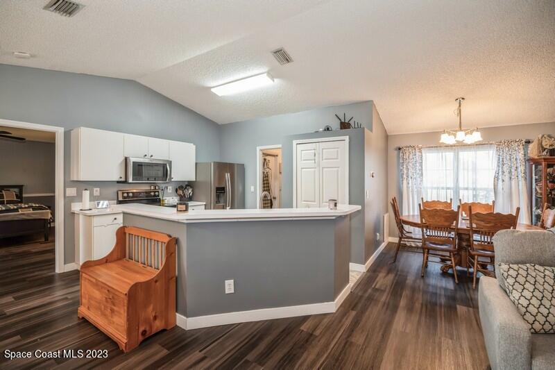6475 Addax Avenue Cocoa, FL 32927 - Photo 5 of 31 a kitchen with a table chairs refrigerator and cabinets