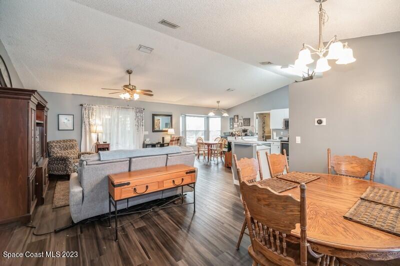 6475 Addax Avenue Cocoa, FL 32927 - Photo 31 of 31 a view of a dining room and livingroom with furniture wooden floor a chandelier