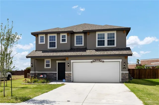 a front view of a house with a garden and yard