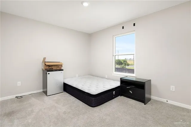 a spacious bedroom with a bed and a window