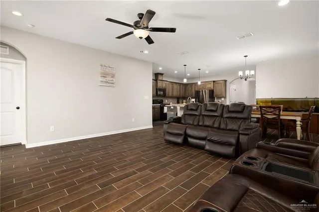 a living room with lots of furniture and a ceiling fan