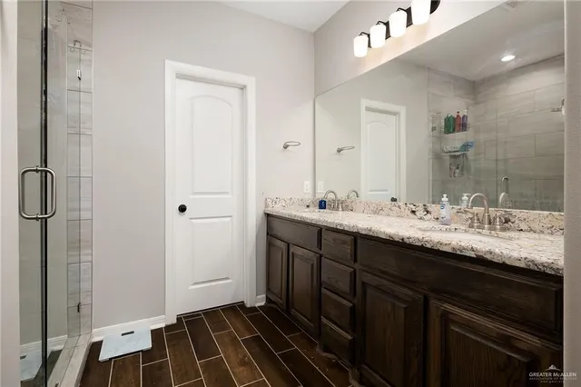 a bathroom with double vanity and a mirror