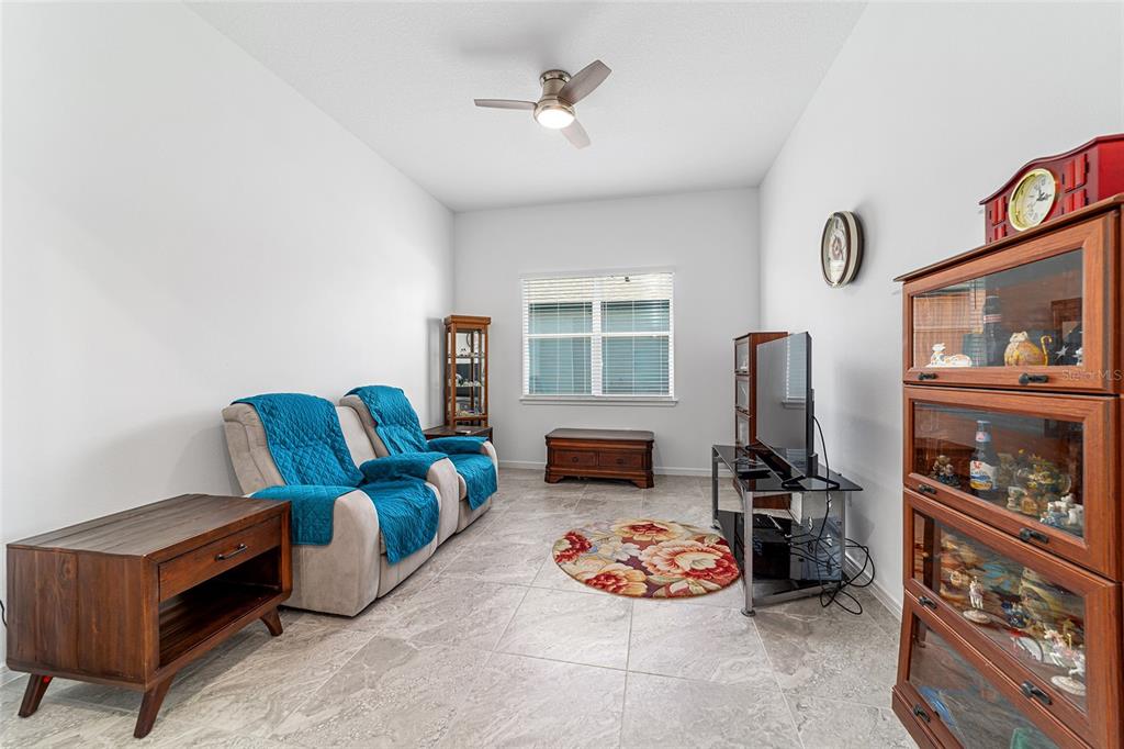 6046 Southwest 86th Circle Ocala, FL 34481 - Photo 53 of 79 a living room with furniture a flat screen tv and a refrigerator