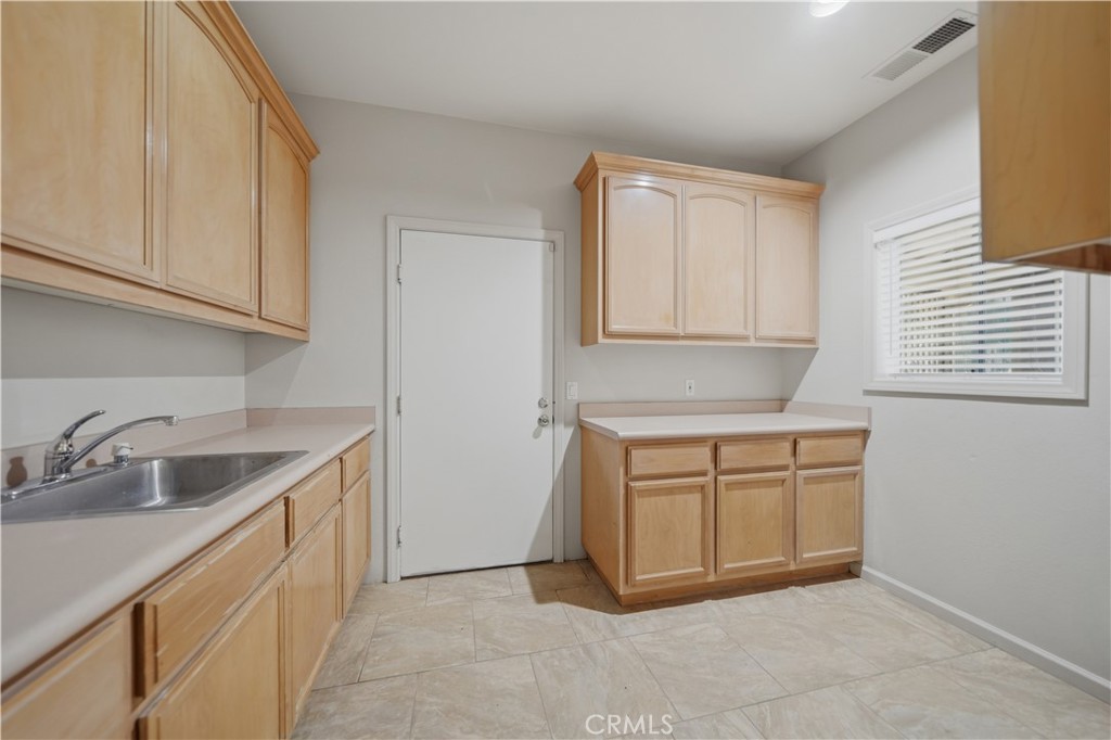 32245 Refa Street Wildomar, CA 92595 - Photo 22 of 69 a kitchen with granite countertop a sink and dishwasher a stove top oven with white cabinets