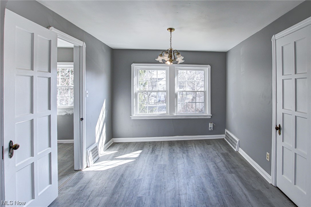 3423 Westbury Road Cleveland, OH 44120 - Photo 25 of 38 Spare room featuring an inviting chandelier, dark hardwood / wood-style floors, and a wealth of natural light