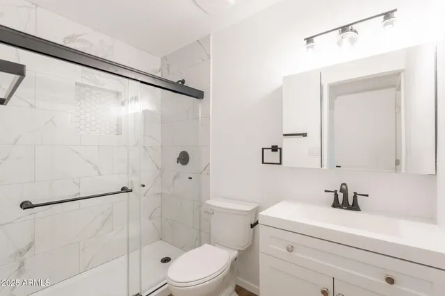 a bathroom with a sink a toilet and shower