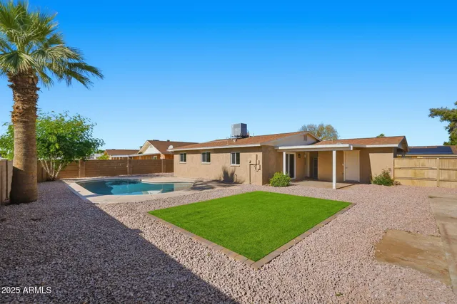 a view of a house with a yard and potted plants