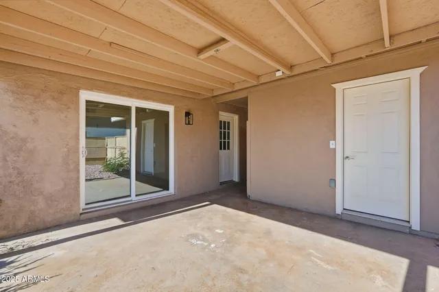 an empty room with sliding door and wooden floor
