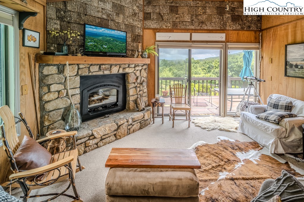 102 Spring Branch Road, Unit E Beech Mountain, NC 28604 - Photo 11 of 40 a living room with furniture a flat screen tv and a fireplace