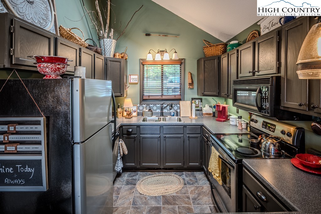 102 Spring Branch Road, Unit E Beech Mountain, NC 28604 - Photo 15 of 40 a kitchen with granite countertop a sink stainless steel appliances and cabinets
