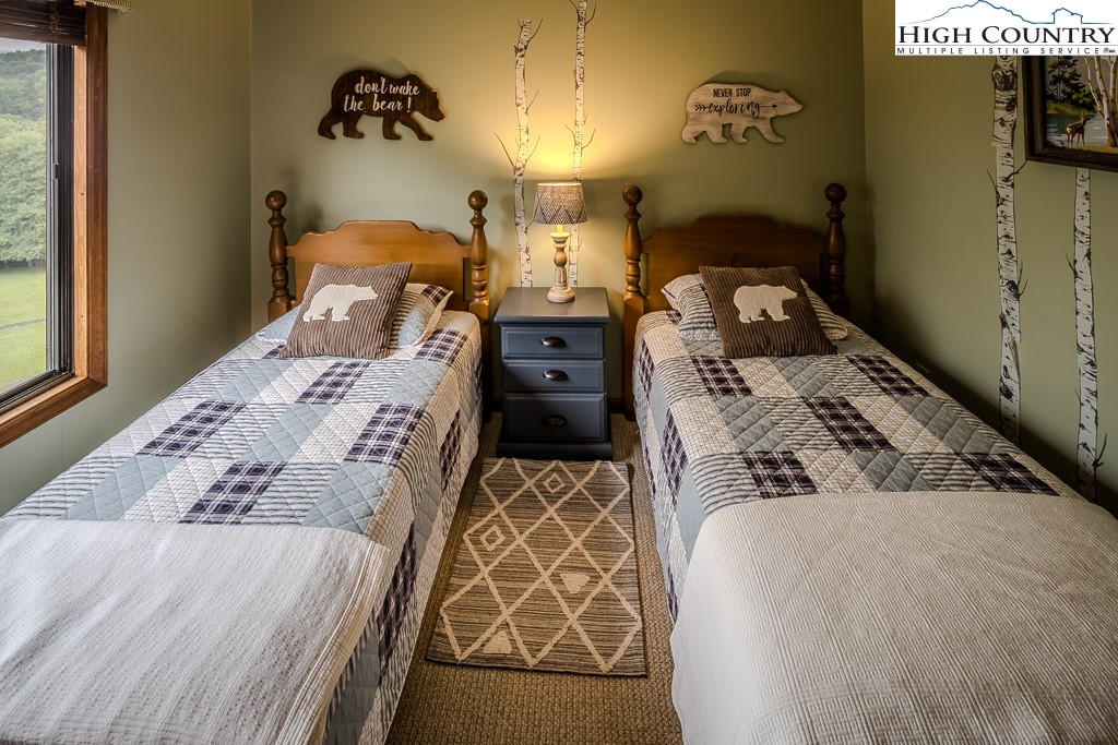 102 Spring Branch Road, Unit E Beech Mountain, NC 28604 - Photo 27 of 40 a bed sitting in a bedroom next to a window