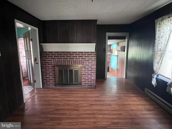 a view of a hallway with wooden floor and a fireplace