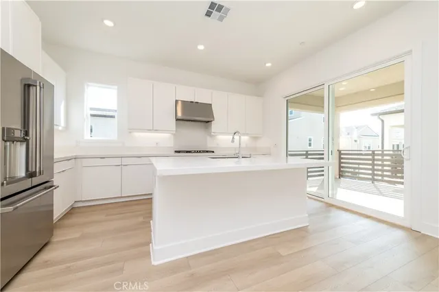 a large white kitchen with a stove a sink and a refrigerator