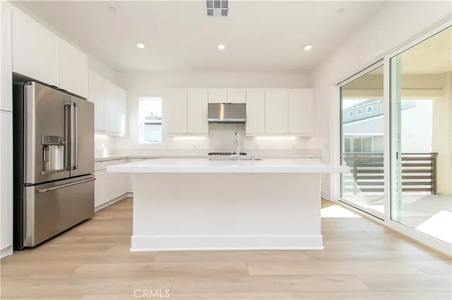 a kitchen with kitchen island a counter top space cabinets and stainless steel appliances