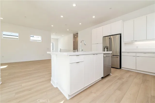 a kitchen with a sink stainless steel appliances and white cabinets