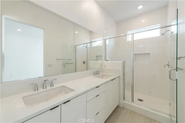 a bathroom with a sink shower and a mirror