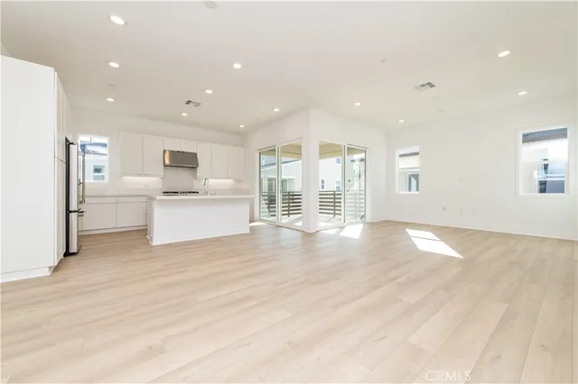 a view of empty room with wooden floor and window