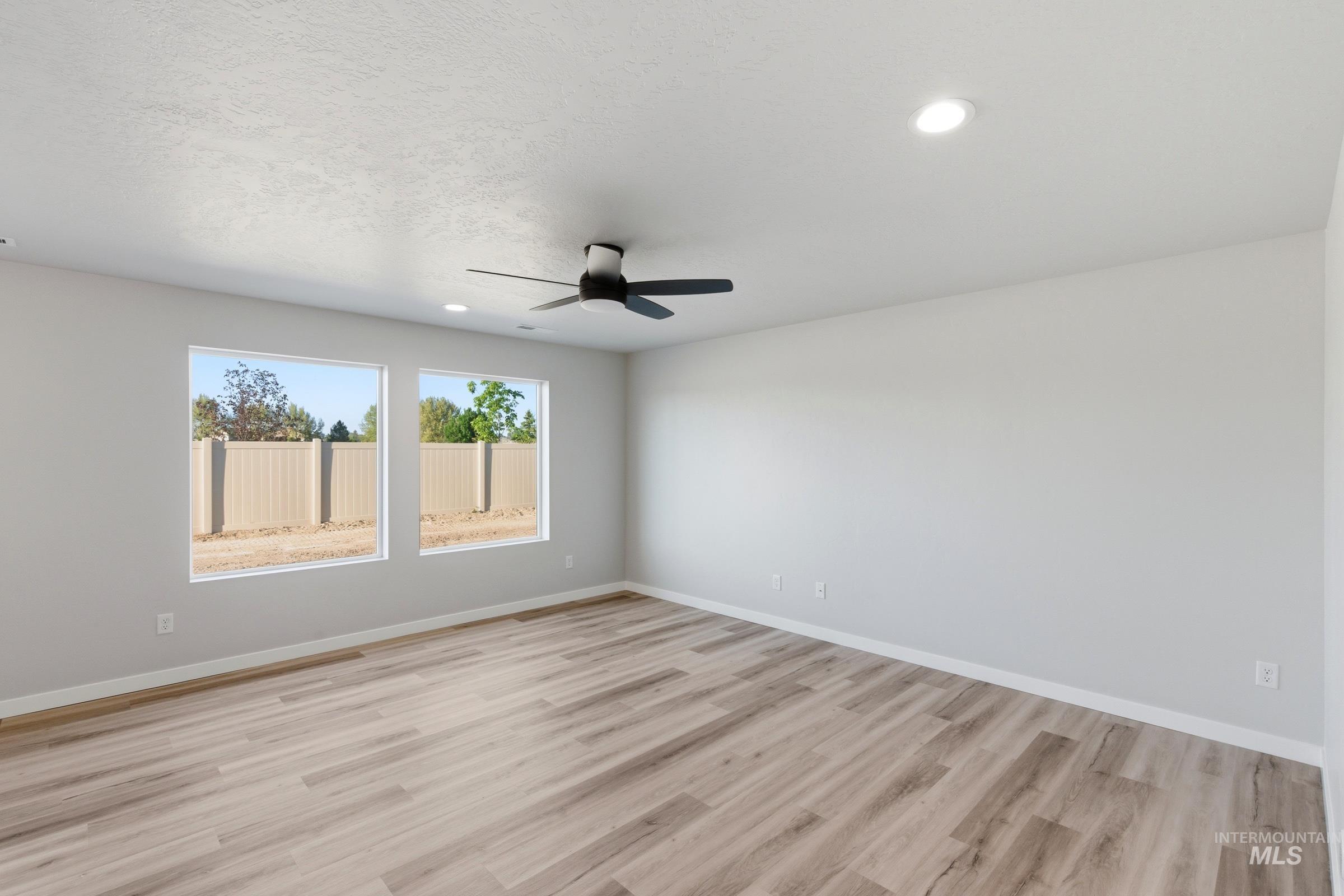 13709 Redway Court Caldwell, ID 83607 - Photo 7 of 28 Spacious room featuring two large windows, wood-finish flooring, a ceiling fan, and recessed lighting