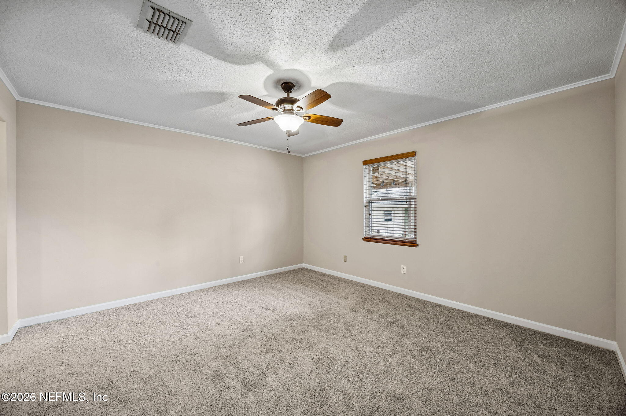 1888 Clemson Road Jacksonville, FL 32217 - Photo 17 of 41 an empty room with a chandelier fan and windows
