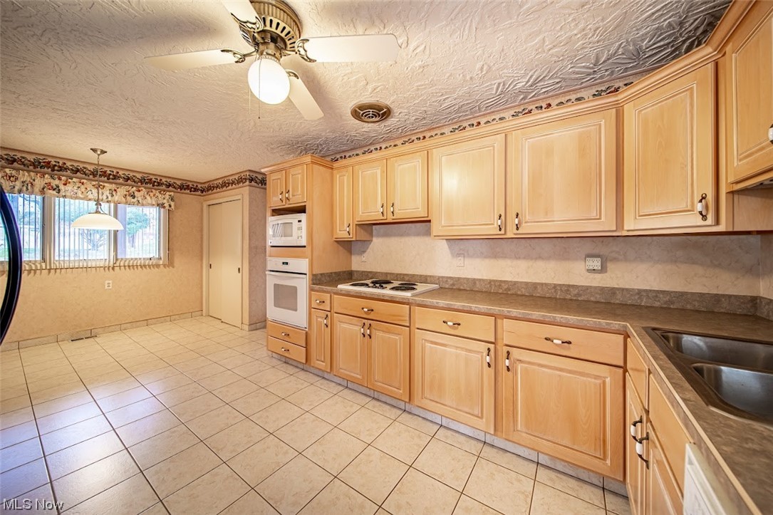 2323 Rockefeller Road Wickliffe, OH 44092 - Photo 3 of 34 Kitchen with decorative light fixtures, sink, ceiling fan, white appliances, and light tile flooring