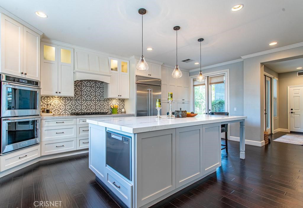23915 Lakeside Road Valencia, CA 91355 - Photo 27 of 74 a kitchen with stainless steel appliances granite countertop a stove a sink a center island a stove and a wooden floor
