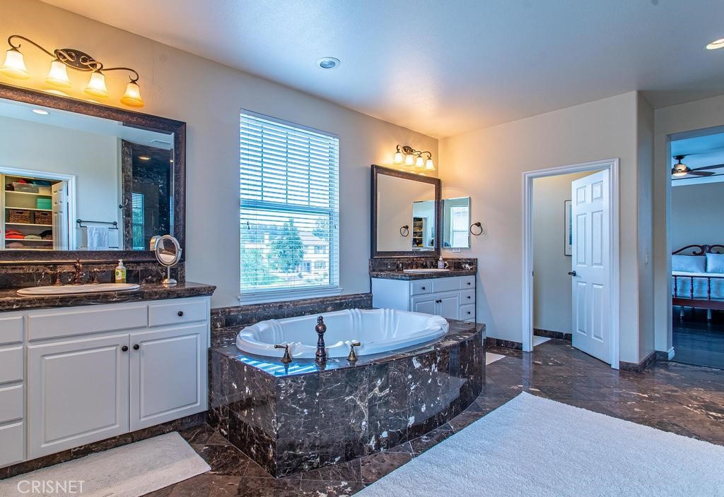 23915 Lakeside Road Valencia, CA 91355 - Photo 44 of 74 a bathroom with a tub a sink and a large mirror
