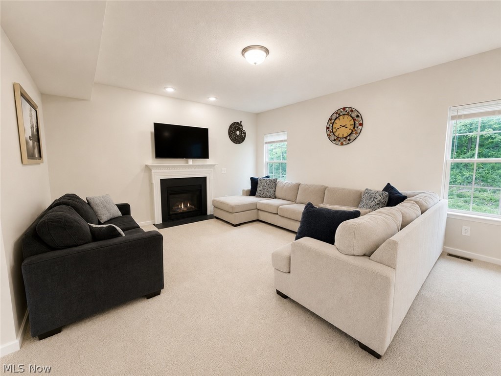 867 Starr Ridge Street Southeast Massillon, OH 44646 - Photo 3 of 29 Carpeted living space featuring a fireplace with a white mantel, recessed lighting, and multiple windows